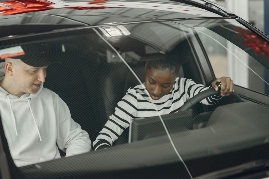 Driving instructor teaching learner driver in car during lesson in Ireland