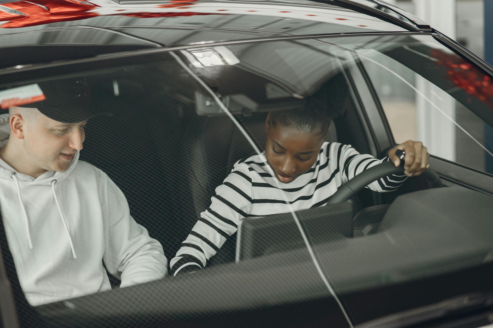 Driving instructor teaching learner driver in car during lesson in Ireland